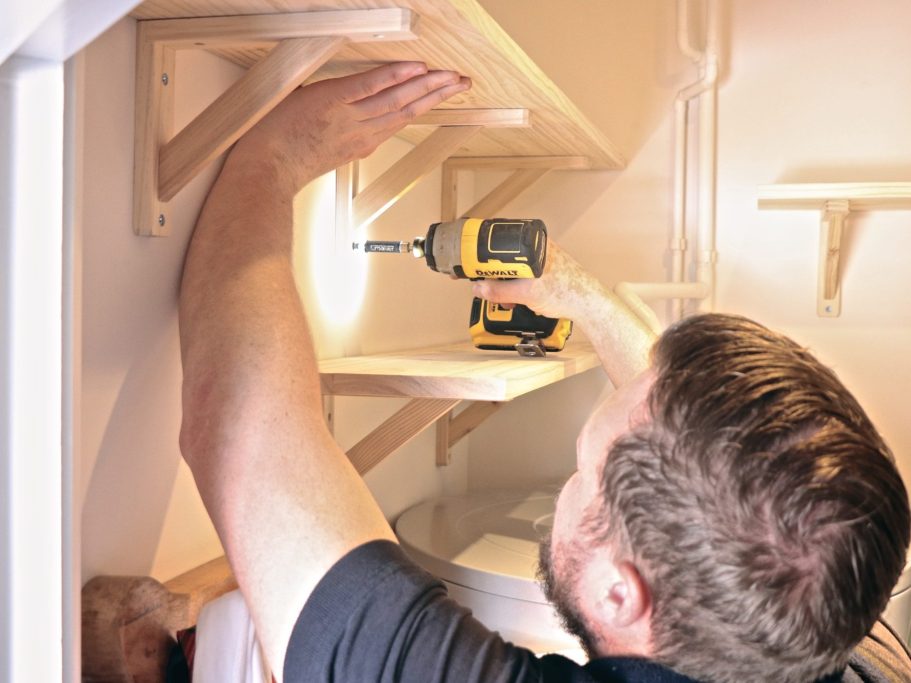 Handyman putting up shelves